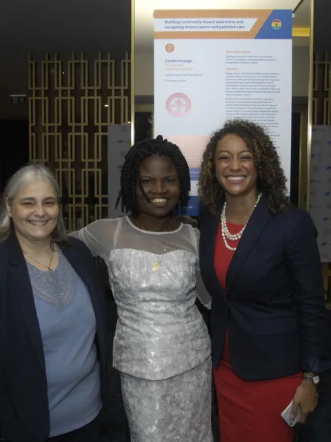 Group of women standing in front of abstract poster and smiling